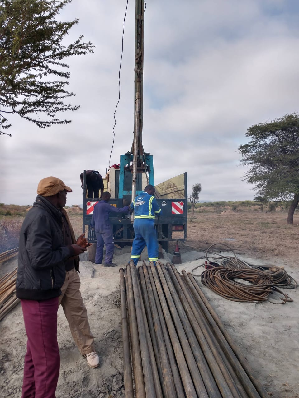 Milimani technical engineering crew lowering submersible pump and riser column into the borehole