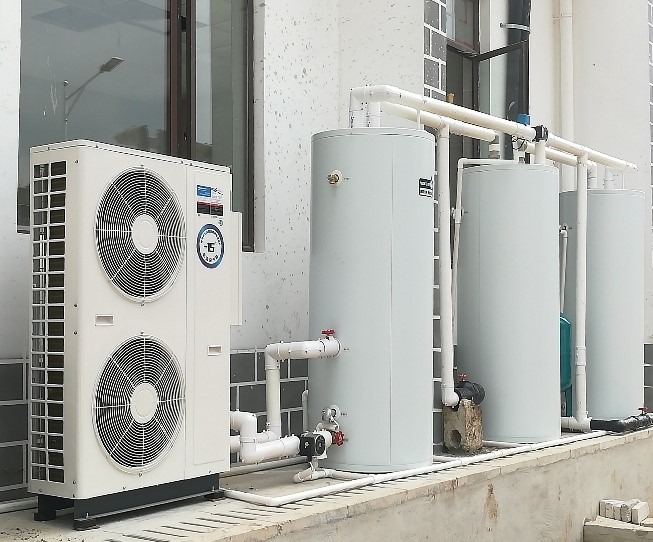 Commercial heat pump water heating installation — compressor units and storage tanks